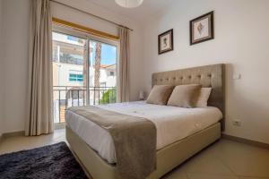 a bedroom with a large bed and a large window at Praia D'el Rey A1 - Golf & Beach in Óbidos