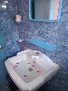 ゴールにあるUma Beach Homeのバスルーム(花の咲く白い洗面台付)