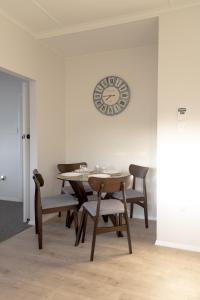a dining room table and chairs with a clock on the wall at House in Palmerston North, New Zealand in Palmerston North +6 photos