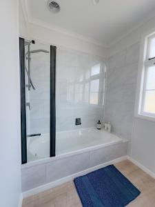 a white bath tub in a bathroom with a window at House in Palmerston North, New Zealand in Palmerston North