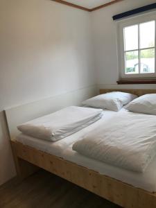a bedroom with two beds with white sheets and a window at Ferienwohnung im Ferienresort Kulkwitzer See Leipzig in Leipzig