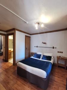 a bedroom with a large bed with blue pillows at Hôtel Restaurant Angival - Chambres et Appartement in Bourg-Saint-Maurice