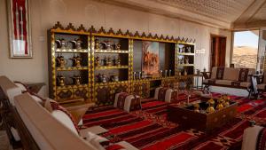 a living room with chairs and a shelf of vases at Desert escape in Al Raka