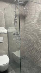 a bathroom with a toilet and a glass shower at Velvet by Poiana Brasov in Poiana Brasov