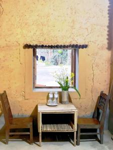 ein Tisch mit zwei Stühlen und ein Fenster in der Unterkunft huy mán bungalow in Ha Giang