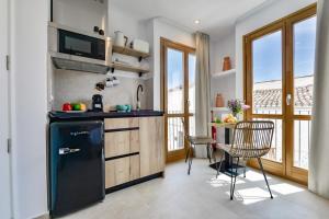 a kitchen with a black refrigerator and a table at MIMAR ALTEA ROOMS - Tranquil in Altea