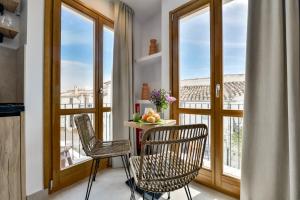 a kitchen with a table and chairs and windows at MIMAR ALTEA ROOMS - Tranquil in Altea