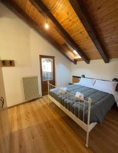 Un dormitorio con una cama y un techo de madera. en TEA San Pellegrino - DOLOMITI, en Falcade