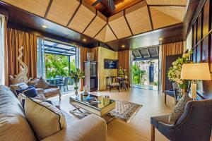 un soggiorno con un divano e un tavolo di Impiana Beachfront Resort Patong, Phuket a Patong Beach