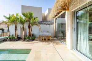 a patio with palm trees and a table at Ixchel Beach House By Sunkeyrents in El Médano