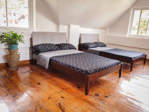 バギオにあるLarge Townhouse w big garden and bonfire Dの木製の床の部屋にベッドが2つあります