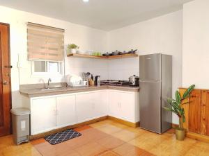 バギオにあるLarge Townhouse w big garden and bonfire Dの白いキャビネットとステンレス製の冷蔵庫を備えたキッチン +9枚の写真