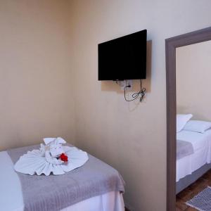 a room with a tv on the wall and a bed at Pousada Tapajos Bonito in Bonito +17 photos