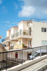 a white building with a fence in front of it at Green Oasis Penthouse in Peyia