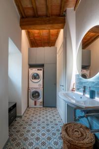 a bathroom with a washing machine and a sink at Palazzo Luparelli Boutique Apartment in Colle Val D'Elsa +45 photos