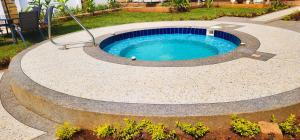 a circular pool in a garden with ascribed at Tulivu Suites in Kakamega