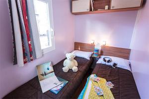 a small bedroom with a teddy bear sitting on a bed at Mobil Home 2 chambre 4 à 6 personne en camping 4 étoiles in Torreilles