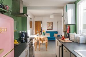 a kitchen with green walls and a dining room at Fern Cottage by Keepers Cottages in Whitstable