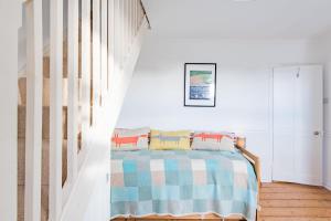 a bedroom with a bed with a striped blanket at Fern Cottage by Keepers Cottages in Whitstable