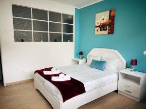 a bedroom with a white bed and blue walls at Ap Centro de Gaia in Vila Nova de Gaia