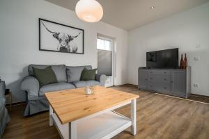 un salon avec un canapé et une table dans l'établissement Ferienhaus-Schilfblick, à Buchholz