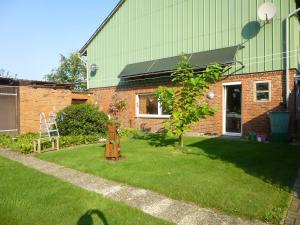 a house with a yard with a tree and a building at Ferienwohnung Stoeterau - ebenerdige FeWo mit Sonnenterrasse in Erfde