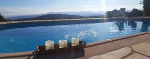 ein Schwimmbad mit Blick auf die Berge in der Unterkunft Les Chardons Bleus in Saint-Laurent-sous-Coiron
