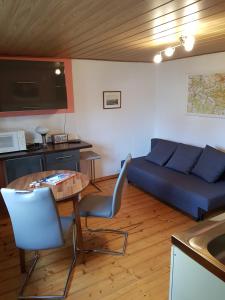 a living room with a blue couch and a table at Ferienhaus Storchennest in Hohnstein