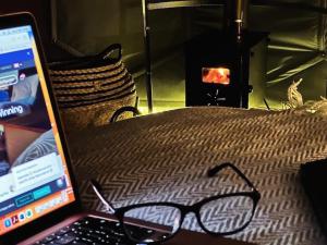 a pair of glasses sitting on a bed next to a laptop at Deerstone Glamping -Malham Cove Dome in Earby