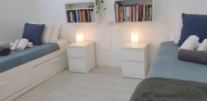 two beds in a room with two lights on them at La dolce vita in Mala
