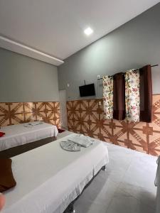 a hotel room with two beds and a television at Hotel B&B in Santa Inês