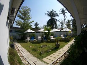 a view of a courtyard with chairs and umbrellas at Langkawi Chantique in Pantai Cenang