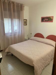 een slaapkamer met een bed met twee stoelen en een raam bij Appartamento Eleonora in Sirmione