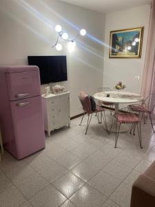 een keuken met een roze koelkast en een tafel met stoelen bij Appartamento Eleonora in Sirmione