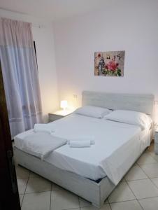 a bedroom with a large white bed in a room at La Casa di Rossella nel cuore della città , Downtown spacious apartment in Olbia +18 photos