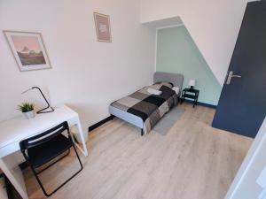 a bedroom with a bed and a desk in a room at Maison Lilloise 6 people heart of Roubaix in Roubaix