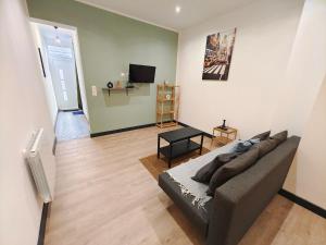 a living room with a couch and a television at Maison Lilloise 6 people heart of Roubaix in Roubaix