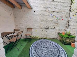 a room with a table and chairs and a brick wall at Maison Lilloise 6 people heart of Roubaix in Roubaix