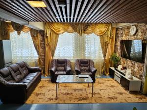 a living room with two leather couches and a tv at Hotel Ilomantsi North Star in Ilomantsi