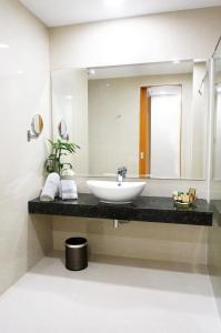 a bathroom with a sink and a mirror at The Waterfront Hotel Kuching in Kuching