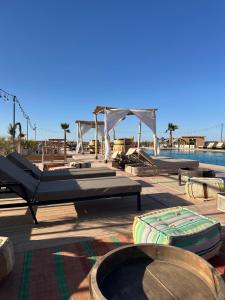 a resort with a pool and a pavilion with beds at Agafay Valley in Marrakesh