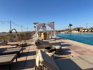 a patio with a pool with a tent and a table at Agafay Valley in Marrakesh