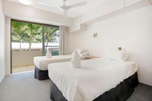 two beds in a room with a large window at Noosasoon - Central Family Friendly Holiday Apt with Pool in Noosa Heads +13 photos