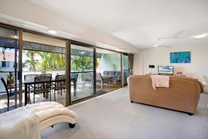 a living room with a couch and a table at Noosasoon - Central Family Friendly Holiday Apt with Pool in Noosa Heads