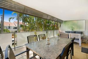 a dining room with a table and chairs on a balcony at Noosasoon - Central Family Friendly Holiday Apt with Pool in Noosa Heads