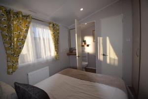 ein Schlafzimmer mit einem Bett und einem Fenster in der Unterkunft 25 Poplars Way Walton on Naze in Walton-on-the-Naze