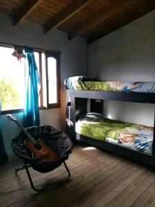 a room with two bunk beds and a guitar at Casa de campo y mar in Camet Norte
