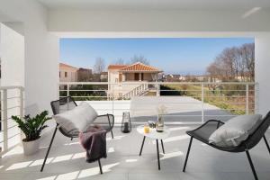 a balcony with chairs and a table on a patio at Villa Georgiana in Funtana