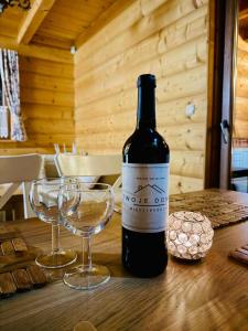 a bottle of wine and two glasses on a table at Willa Koniora - sauna, balia, biliard in Międzybrodzie Bialskie