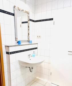 a white bathroom with a sink and a mirror at Hotel Am Weyerhof in Kerpen